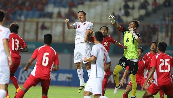 Anh Đức bật cao đánh đầu trước vòng vây của hậu vệ Olympic Nepal. - Sputnik Việt Nam