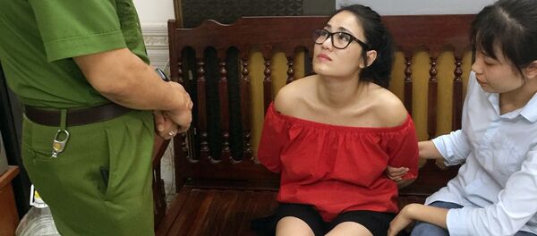 Đối tượng Bùi Thị Thu Trang (áo đỏ) bị bắt tại nơi ở. Đối tượng Bùi Thị Thu Trang (áo đỏ) bị bắt tại nơi ở. - Sputnik Việt Nam