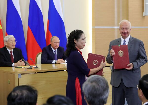 Ngày 6 tháng Chín năm 2018. Tổng thống Nga Vladimir Putin tại lễ ký kết sau cuộc hội đàm với Tổng bí thư Đảng Cộng sản Việt Nam Nguyễn Phú Trọng. Từ phải sang trái - Đại sứ LB Nga tại Việt nam Konstantin Vnukov và Thứ trưởng Bộ Văn hóa, Thể thao và Du lịch Việt Nam Đặng Thị Bích Liên. - Sputnik Việt Nam