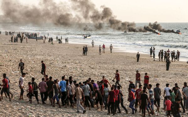 Những người Palestine đang khiêng một người trúng thương trong vụ đụng độ với binh lính Israel ở dải Gaza - Sputnik Việt Nam