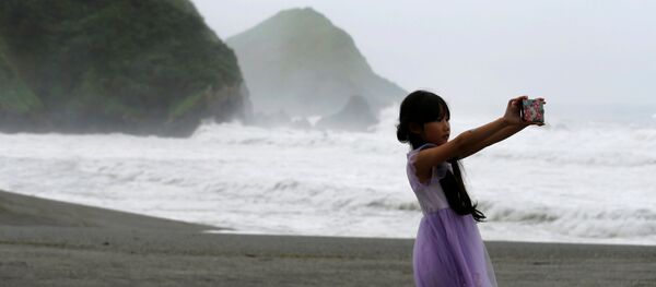 Cô gái đang chụp ảnh selfie trong khi xảy ra cơn bão Nepartak ở Đài Loan - Sputnik Việt Nam