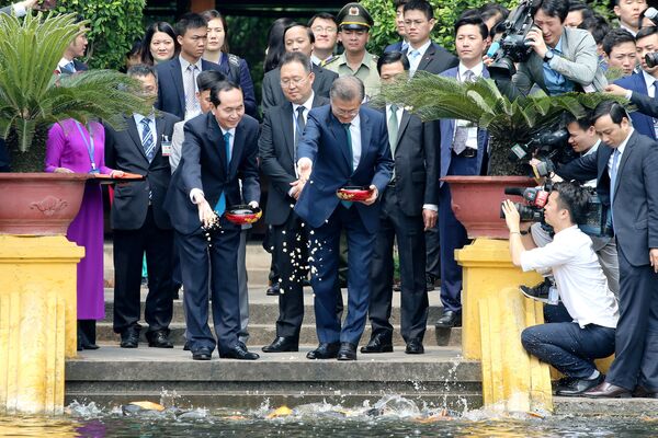 Tổng thống Hàn Quốc Moon Jae-in và Chủ tịch nước Việt Nam Trần Đại Quang cho cá ăn trong ao bên cạnh Phủ Chủ tịch tại Hà Nội - Sputnik Việt Nam
