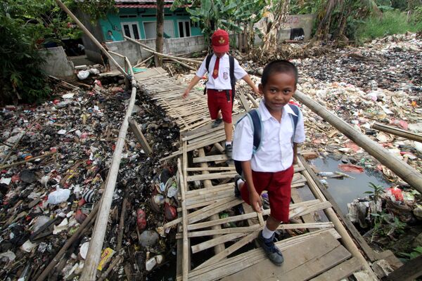 Các học  trò đi cầu tre trên nhánh sông Chiliwong ngập rác ở Indonesia - Sputnik Việt Nam