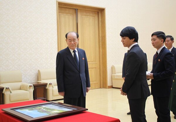 Đại sứ Việt Nam Lê Bá Vinh (hàng đầu, bên phải) trao bức tranh cho ông Kim Yong-nam (hàng đầu, trái). Đại sứ Việt Nam Lê Bá Vinh (hàng đầu, bên phải) trao bức tranh cho ông Kim Yong-nam (hàng đầu, trái). - Sputnik Việt Nam