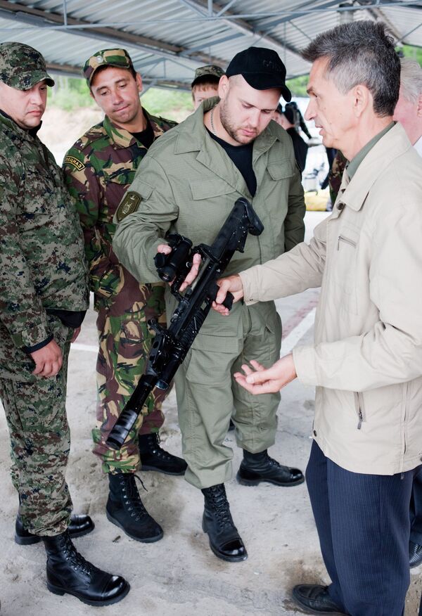 Nhà thiết kế trưởng Vasily Bolotnikov (bên phải) hướng dẫn sĩ quan và quân nhân hợp đồng xử dụng súng ADS (súng trường tấn công nhiều môi trường) trong khóa đào tạo và huấn luyện cho lính lặn đặc công của các đơn vị Bộ Nội vụ Nga tại trung tâm đào tạo Severobaikalsk. - Sputnik Việt Nam