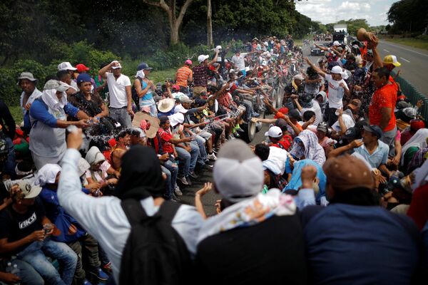 Central American migrants, who are part of a caravan of migrants trying to reach the United States, hitchhike on a truck along the highway as they continue their journey in Tapachula, Mexico October 22, 2018 - Sputnik Việt Nam