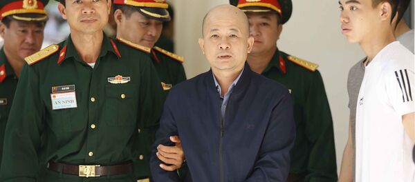 Lực lượng chức năng dẫn giải bị cáo Đinh Ngọc Hệ vào phiên xét xử. - Sputnik Việt Nam