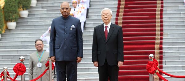 Tổng Bí thư, Chủ tịch nước Nguyễn Phú Trọng và Tổng thống Ấn Độ Ram Nath Kovind trên bục danh dự, thực hiện nghi lễ chào cờ. - Sputnik Việt Nam