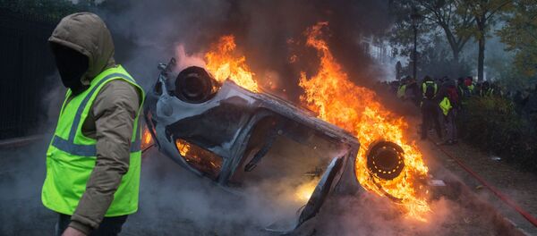 Chiếc xe bị đốt cháy trong phong trào biểu tình phản đối áo ghi lê vàng ở Paris - Sputnik Việt Nam