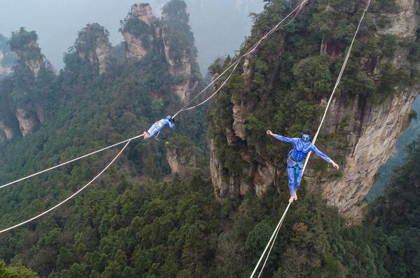 Hai người tham gia hóa trang thành các nhân vật trong bộ phim Avatar tại cuộc thi slackline ở dãy núi Huanshizhai ở tỉnh Hồ Nam miền trung Trung Quốc - Sputnik Việt Nam