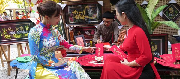 Du khách lựa chọn thư pháp tại phố ông đồ “Trẻ”. - Sputnik Việt Nam