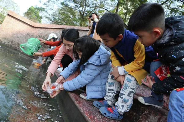 Cô giáo dạy các em học sinh thả cá chép đúng cách. Cô giáo dạy các em học sinh thả cá chép đúng cách. - Sputnik Việt Nam