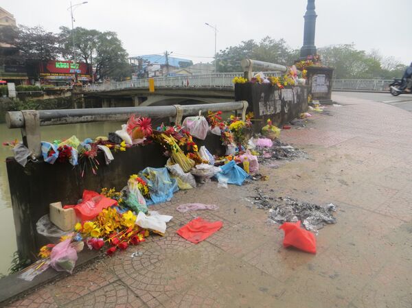 Đồ cúng vứt bừa bãi trên hàng rào và lề đường - Sputnik Việt Nam