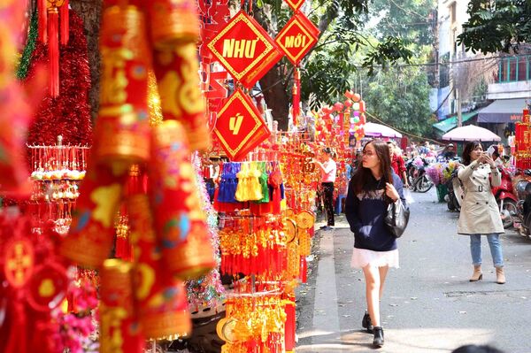 Người dân thủ đô mua sắm hàng Tết tại tuyến phố Hàng Mã.  - Sputnik Việt Nam