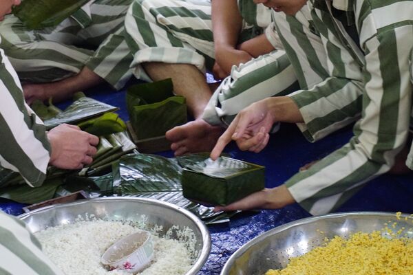 Các phạm nhân cùng nhau gói bánh để chuẩn bị cho Tết cổ truyền. - Sputnik Việt Nam
