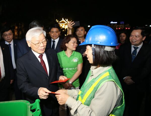 Tổng Bí thư, Chủ tịch nước Nguyễn Phú Trọng mừng tuổi, chúc Tết công nhân công ty Vệ sinh Môi trường Hà Nội đang làm việc trên đường Thanh Niẻn.  - Sputnik Việt Nam
