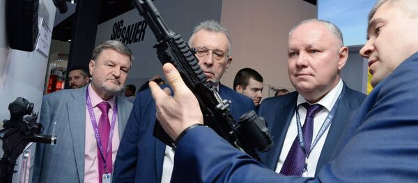 Tổng giám đốc Công ty Cổ phần Rosoboronexport Alexander Mikheev (thứ hai từ phải sang) xem xét khẩu súng trường tấn công Kalashnikov loại 200 tại triển lãm vũ khí quốc tế IDEX-2019 ở Abu Dhabi - Sputnik Việt Nam