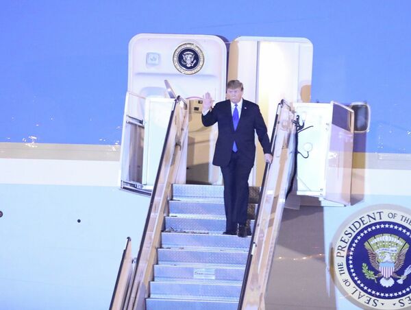 Tổng thống Mỹ Donald Trump vừa xuống cầu thang máy bay vừa vẫy tay chào các đại biểu và người dân Thủ đô ra đón tại sân bay quốc tế Nội Bài. - Sputnik Việt Nam