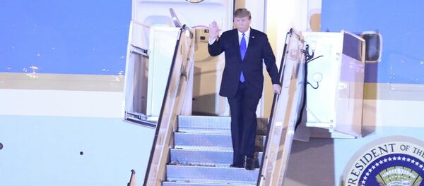 Tổng thống Mỹ Donald Trump vừa xuống cầu thang máy bay vừa vẫy tay chào các đại biểu và người dân Thủ đô ra đón tại sân bay quốc tế Nội Bài. - Sputnik Việt Nam