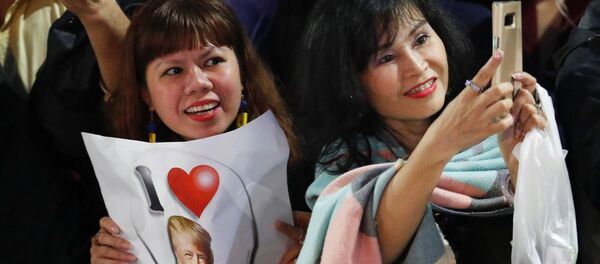 Người dân cầm biểu ngữ, cờ hoa chào mừng trước khách sạn Metropol ở Hà Nội trong trong Hội nghị thượng đỉnh Mỹ-Triều lần hai - Sputnik Việt Nam