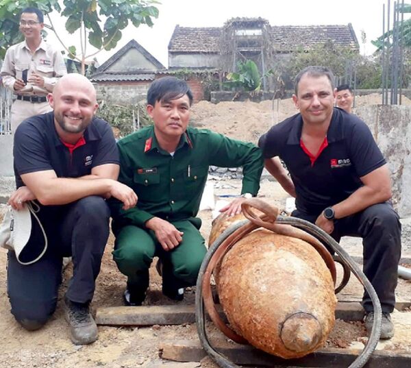 Jack Cambpell (trái) và Guy Damien Lakin cùng cán bộ quân sự Việt Nam sau khi tháo gỡ thành công ngòi nổ quả bom 334 kg - Sputnik Việt Nam