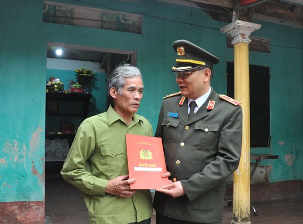 Thiếu tướng Tô Ân Xô - Giám đốc Công an tỉnh Bắc Giang trao quyết định thăng cấp bậc hàm lên Trung tá cho gia đình anh Nguyễn Quang Luận - Sputnik Việt Nam