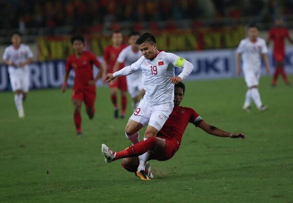 Quang Hải (số 19) nỗ lực đi bóng trong sự truy cản quyết liệt của hậu vệ U23 Indonesia. Quang Hải (số 19) nỗ lực đi bóng trong sự truy cản quyết liệt của hậu vệ U23 Indonesia. - Sputnik Việt Nam