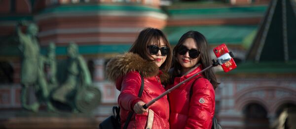 Девушки делают селфи на фоне храма Василия Блаженного в Москве - Sputnik Việt Nam