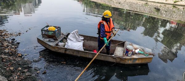 Các công nhân vệ sinh phải thường xuyên thu dọn rác thải trên bề mặt sông - Sputnik Việt Nam