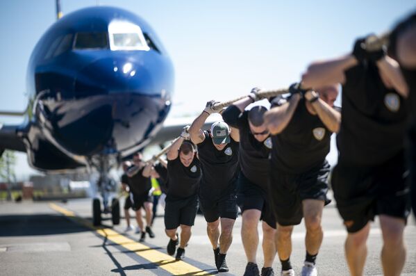 Những người tham gia cuộc thi hàng năm Plane Pull kéo chiếc máy bay JetBlue A320 tại Sân bay Quốc tế John Kennedy ở New York - Sputnik Việt Nam