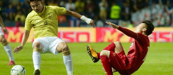 Tiền vệ Quang Hải của Việt Nam bị ngã sau pha phạm lỗi của tiền vệ Thitiphan bên phía Thái Lan.  - Sputnik Việt Nam