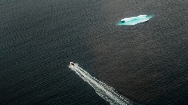 Một chiếc thuyền đi ngang qua tảng băng trôi trong đại dương gần Tasiilaq, Greenland - Sputnik Việt Nam