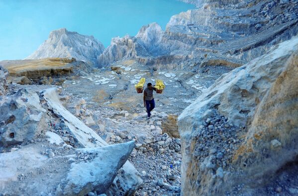  Thợ mỏ khuân vác túi lưu huỳnh từ mỏ đá trên núi lửa Kawah Ijen đang hoạt động ở Indonesia - Sputnik Việt Nam