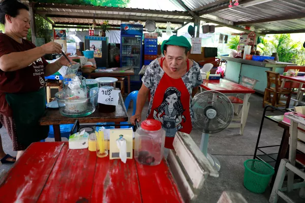 Một người bán hàng rong nhìn vào con rắn hổ mang bị bắt và nhốt trong chai nhựa ở Bangkok, Thái Lan Một người bán hàng rong nhìn vào con rắn hổ mang bị bắt và nhốt trong chai nhựa ở Bangkok, Thái Lan - Sputnik Việt Nam