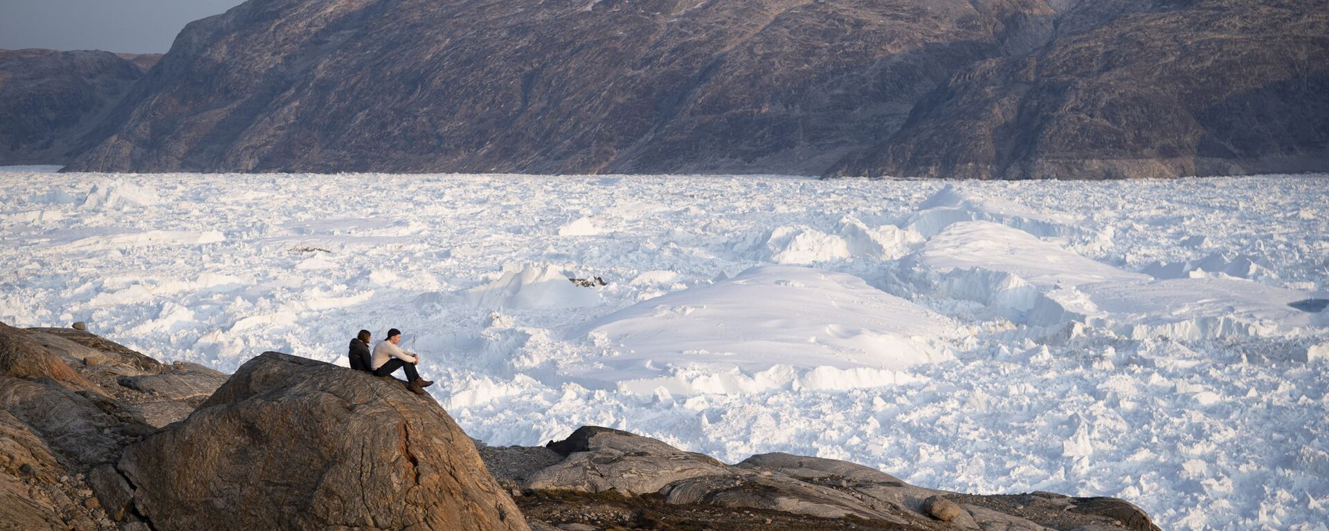 Sinh viên Đại học New York ngồi trên vách đá nhìn xuống sông băng Helheim ở Greenland - Sputnik Việt Nam, 1920, 03.08.2023