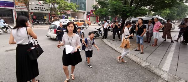 Các bậc phụ huynh đưa con đến được cô giáo chủ nhiệm đón tại cổng trường - Sputnik Việt Nam