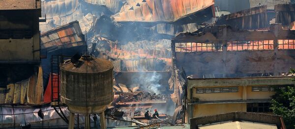 Cảnh sát phòng cháy, chữa cháy phun nước vào khu vực còn khói. - Sputnik Việt Nam