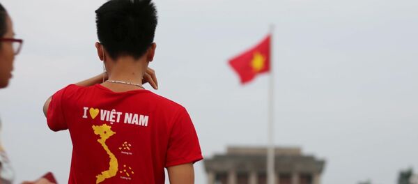 Một thanh niên mặc áo in hình Tổ quốc, ngắm nhìn lá Quốc kỳ trên Quảng trường Ba Đình, sáng 2/9/2019.  - Sputnik Việt Nam