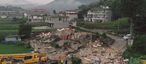 Lực lượng cứu hộ đang tìm kiếm dưới đống đổ nát của người sống sau trận động đất ở tỉnh Tứ Xuyên của Trung Quốc - Sputnik Việt Nam