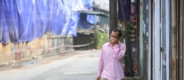 Người dân lấy tay che mặt mỗi khi đi qua khu vực cháy.  - Sputnik Việt Nam