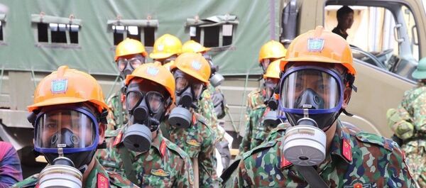 Lực lượng Binh chủng Hoá học triển khai lực lượng giải phóng hiện trường trước khi tiến hành tẩy độc mặt nền nhà xưởng bị cháy.  - Sputnik Việt Nam