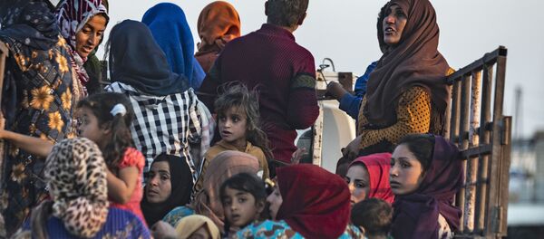 Dân thường Syria và người Kurd Syria chạy trốn khỏi vụ đánh bom của Thổ Nhĩ Kỳ vào thành phố Ras al Ain của Syria giáp biên giới với Thổ Nhĩ Kỳ - Sputnik Việt Nam