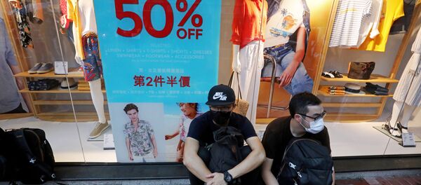 Người dân gần một cửa hàng đóng cửa vì các cuộc biểu tình ở Hồng Kông - Sputnik Việt Nam