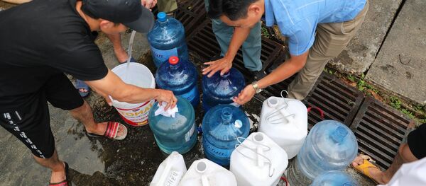 Người dân xếp hàng chờ lấy nước miễn phí tại Nhà máy nước Hạ Đình (địa chỉ, số 14 Ngõ 192 Phố Hạ Đình).  - Sputnik Việt Nam