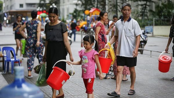 Hình ảnh người dân KĐT Linh Đàm (Hoàng Mai, Hà Nội) rồng rắn xách xô chậu đi lấy nước sạch từ tét nước dịch vụ đã đang diễn ra trong gần một tuần nay. - Sputnik Việt Nam