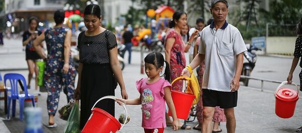 Hình ảnh người dân KĐT Linh Đàm (Hoàng Mai, Hà Nội) rồng rắn xách xô chậu đi lấy nước sạch từ tét nước dịch vụ đã đang diễn ra trong gần một tuần nay. - Sputnik Việt Nam