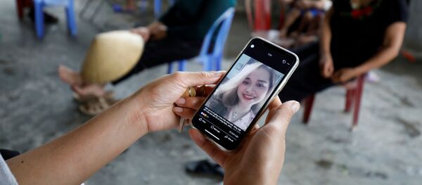 Điện thoại có ảnh Anna Bùi Thị Nhung, một trong những người có thể đã chết trong container ở Essex (Anh), trong tay thân nhân ở Nghệ An - Sputnik Việt Nam