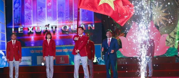 Ông Trần Đức Phấn, Phó Tổng cục trưởng Tổng cục Thể dục thể thao, Trưởng Đoàn thể thao Việt Nam tham dự SEA Games 30 phất cao lá quốc kỳ Việt Nam trong Lễ xuất quân - Sputnik Việt Nam