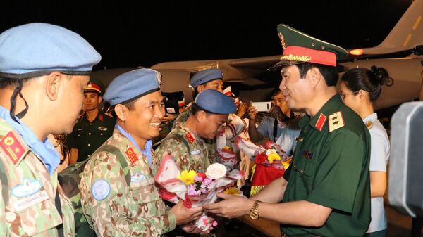 Trung tướng Nguyễn Tân Cương, Phó Tổng tham mưu trưởng Quân đội nhân dân Việt Nam tặng hoa chúc mừng các cán bộ, chiến sỹ Bệnh viện dã chiến cấp 2 số 1 trở về nước trong đợt này. - Sputnik Việt Nam