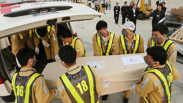 Nhân viên sân bay quốc tế Nội Bài vận chuyển thi thể các nạn nhân lên ô tô để đưa về quê nhà. - Sputnik Việt Nam